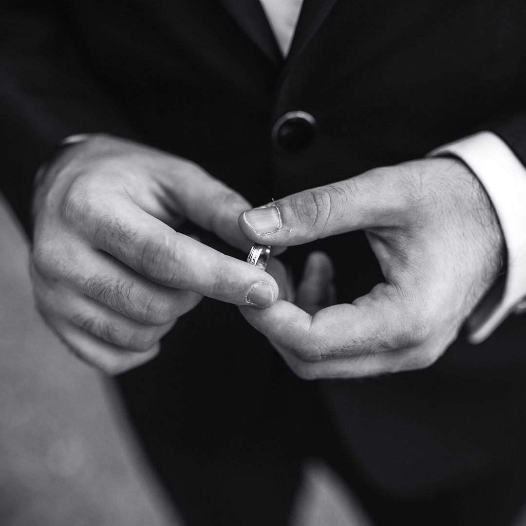 groom holding a wedding ring and waits for bride